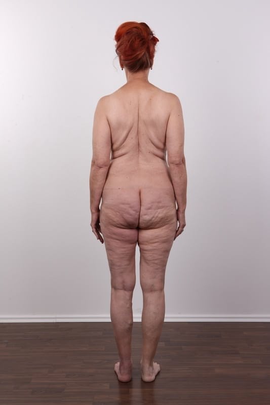 Jitka si spoglia sensualmente fino a restare completamente nuda, mostrando enormi seni naturali mentre è seduta a gambe aperte su uno sgabello di legno. - 9