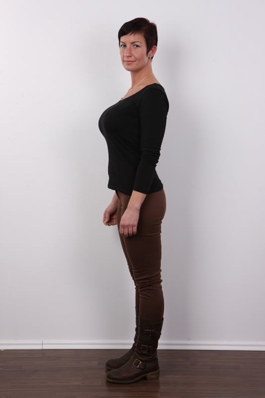 Amateur woman with short hair and big tits sits on a stool after disrobing