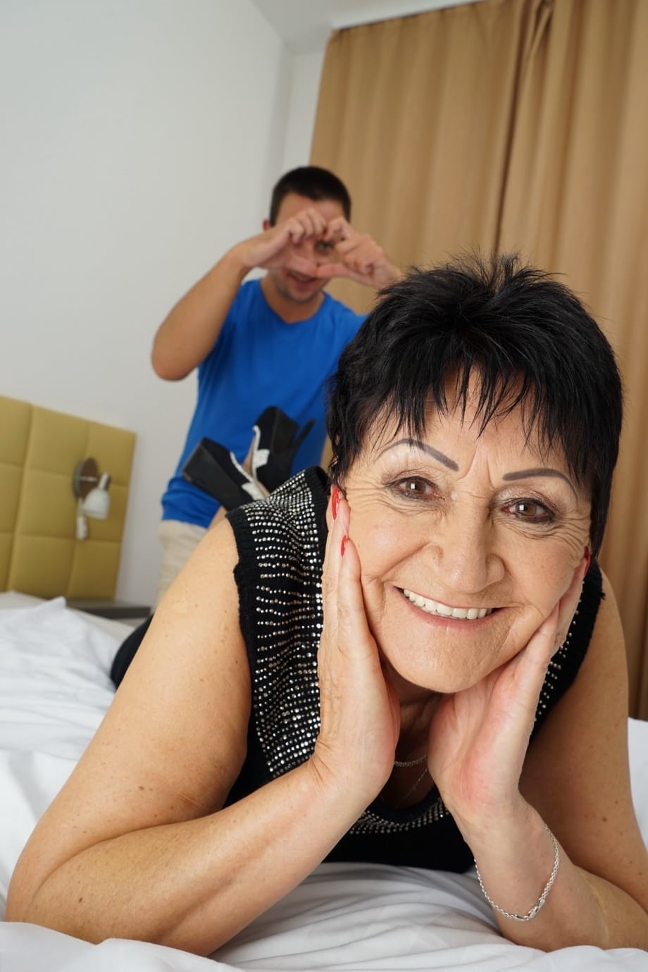 Short haired mature lady gets naked on a bed while having sex