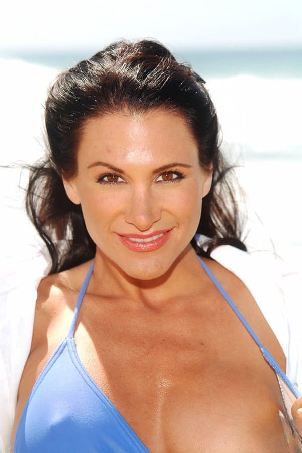 Fabulous MILF Sydnee Steele displays her big tits while stripping on the beach