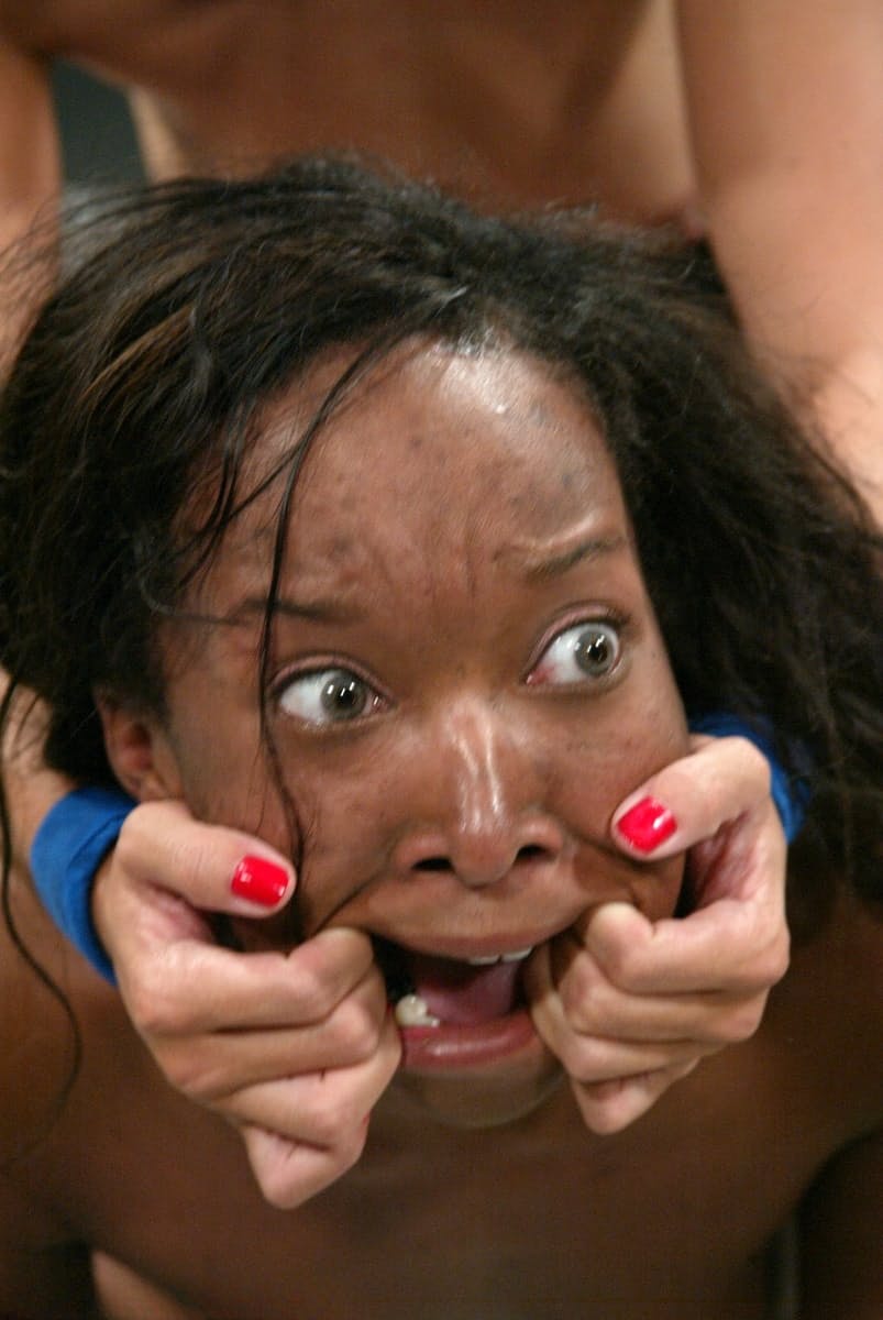 Asian woman tops a black chick during the course of a lesbian wrestling match