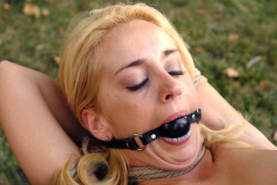 Kelly Wells, jovencita rubia y menuda, siendo follada en la garganta y follada sin protección al aire libre en una hardcore atadura con cuerdas - 7