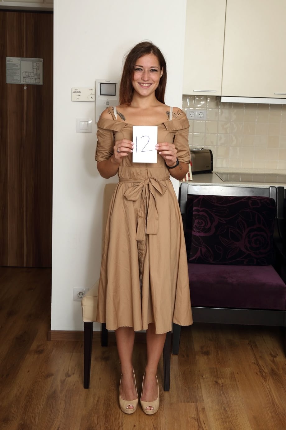 Tall teen Mina K removes an overcoat and underthings to stand naked