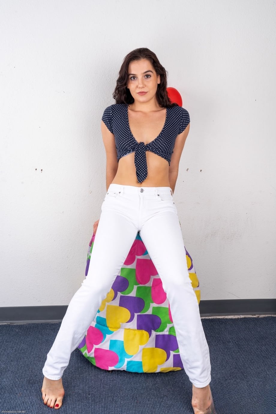 La bellissima Kasey Warner si spoglia nuda dai pantaloni bianchi, stuzzicando sul morbido pouf - 1