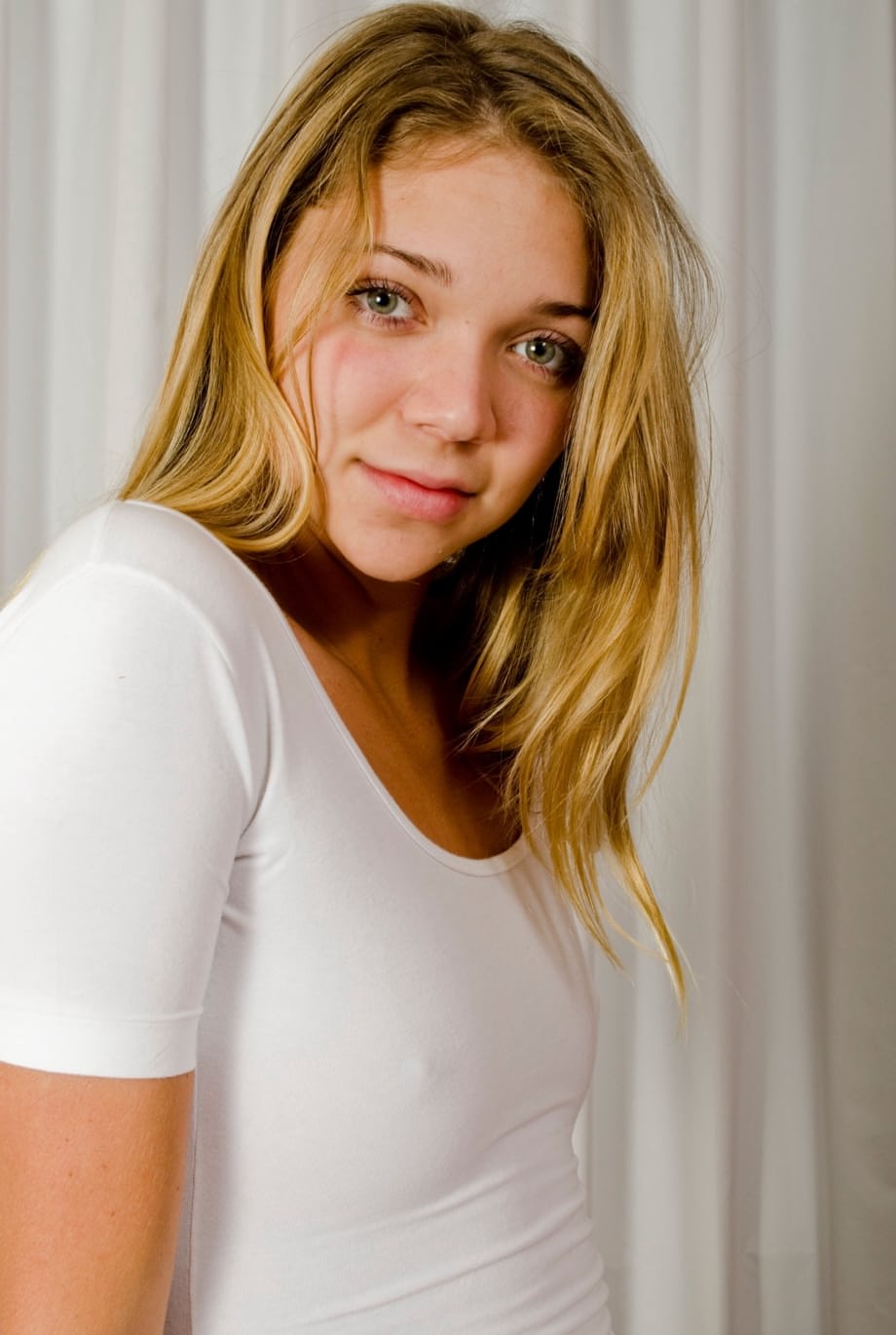 La estrella porno Jessie Andrews se desnuda provocando con sus diminutos pechos firmes mientras posa completamente desnuda en una silla - 3