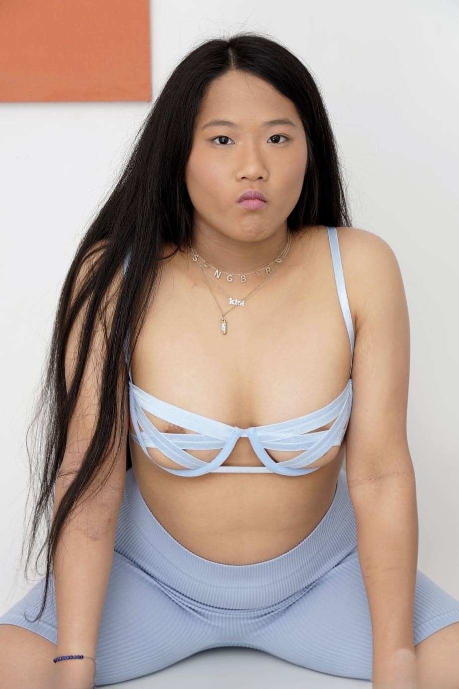 Chubby Asian girl Alona Bloom strips naked and shows off her shaved pussy