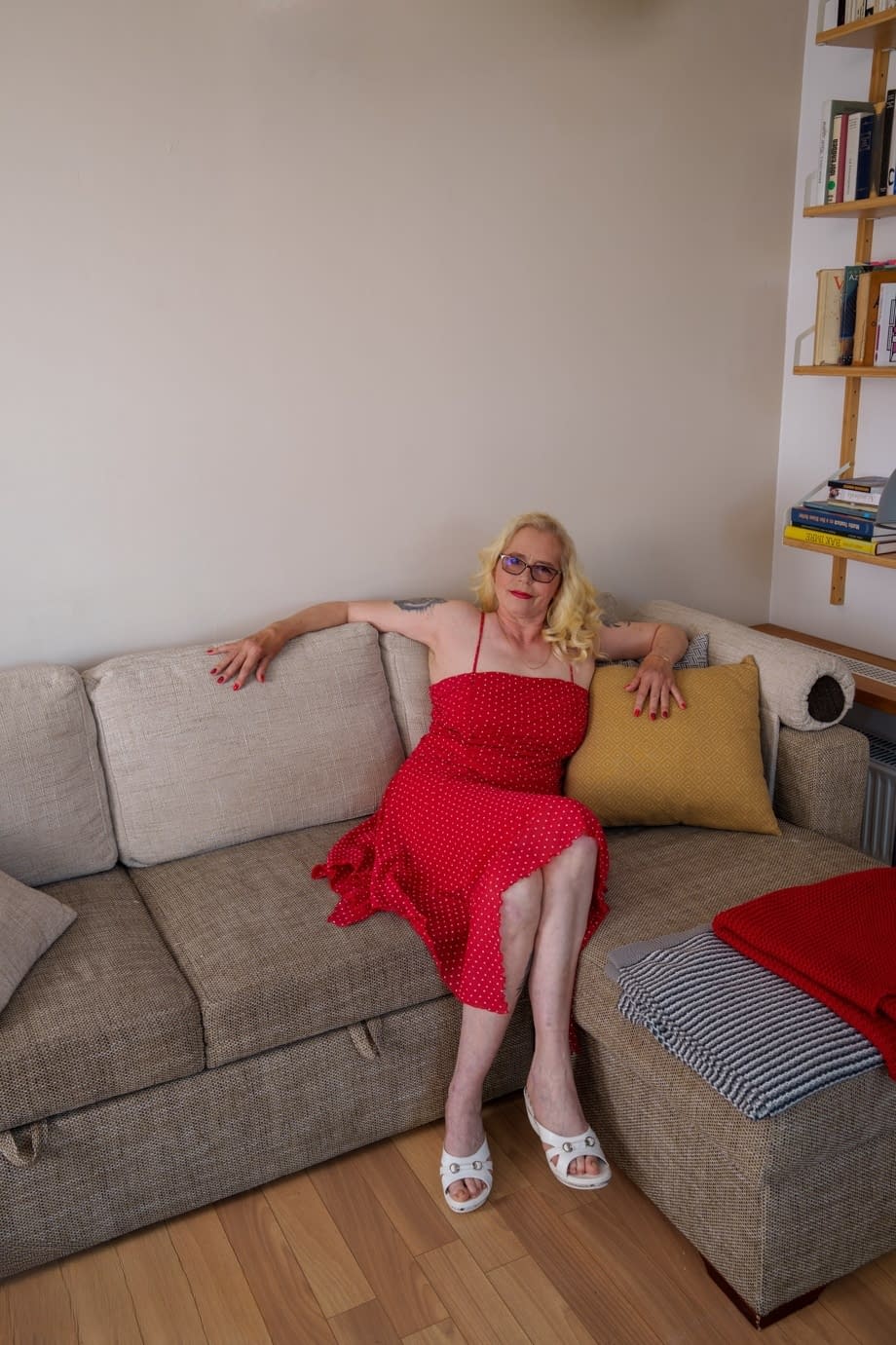 Céleste taquine en lunettes alors que la blonde mature coquine relève sa robe rouge en agrippant son cul. - 1