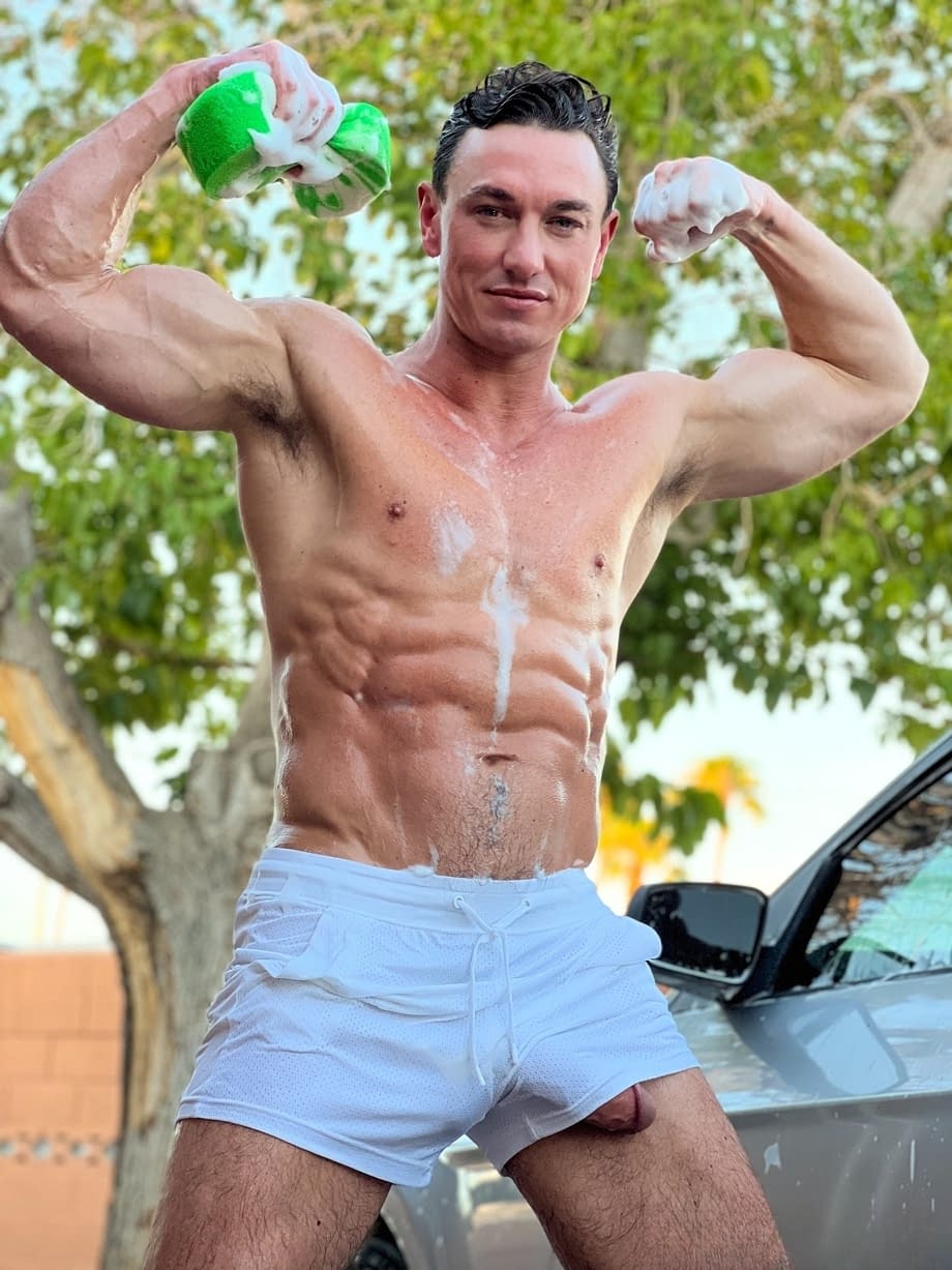 Shirtless gay man shows off his muscles & his big dick while washing his car