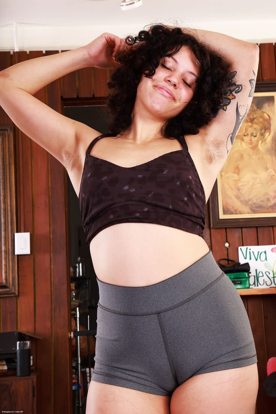 Brunette girl with curly hair shows her bottomless ass and vagina on a yoga mat