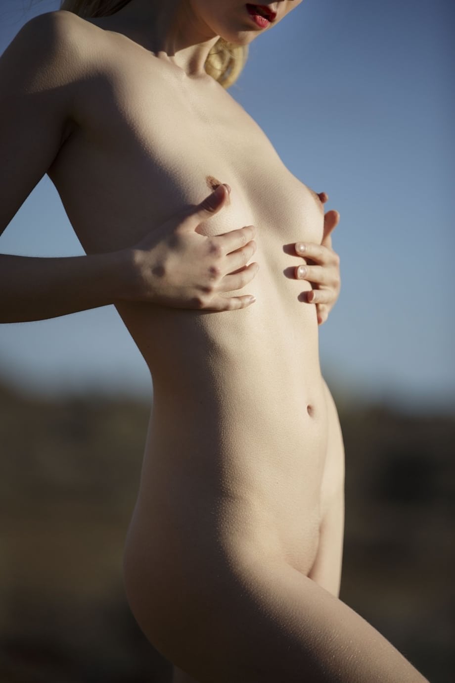 Emmi posando completamente desnuda al aire libre mientras se desviste y provoca con sus curvas sensuales - 17