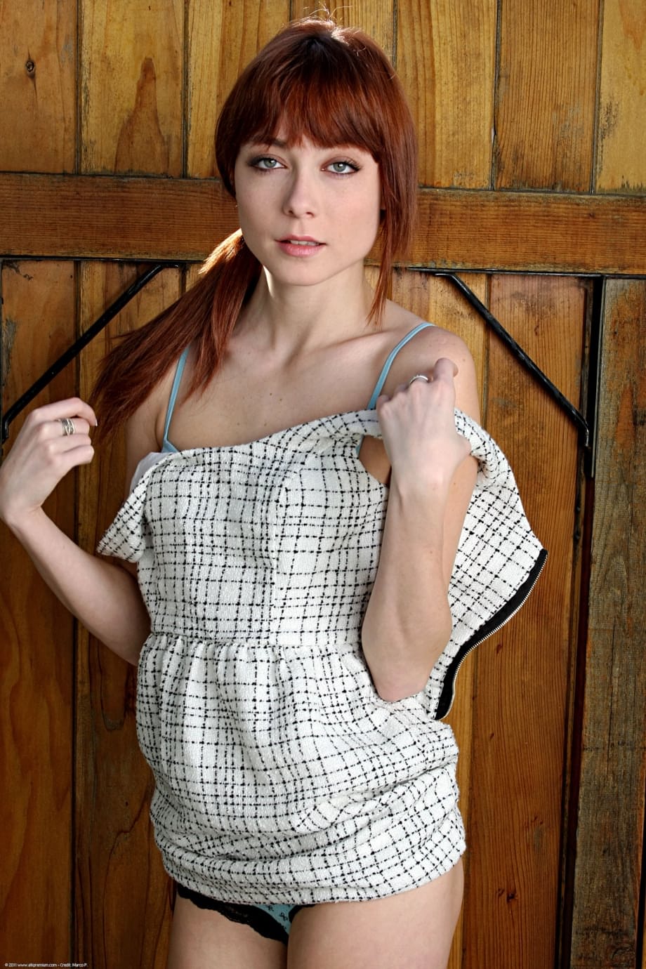 Zoe Voss strips naked in a teasing solo display against rustic wood panels - 5