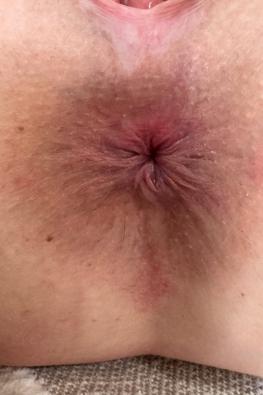 Amateur girl shows off her tiny tits before posing nude on a blanket